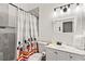 Clean bathroom featuring a modern vanity, a gray tiled shower-tub, and a Mickey Mouse-themed shower curtain at 157 Julliard Blvd, Davenport, FL 33897