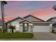 Charming single-story home with a well-manicured lawn, attached garage and tropical landscaping at 157 Julliard Blvd, Davenport, FL 33897