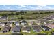 New homes line a street with pond views across from a large grassy area, under a blue sky at 1627 Mclucas Ln, The Villages, FL 34762