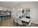 View of the dining area with a modern chandelier, seating for six, and an open view into the kitchen at 1627 Mclucas Ln, The Villages, FL 34762