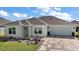 Charming home featuring a manicured lawn, paver driveway, and coordinated landscaping at 1627 Mclucas Ln, The Villages, FL 34762