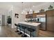 Bright kitchen features an island with bar stool seating, stainless steel appliances, and wood-look flooring at 1627 Mclucas Ln, The Villages, FL 34762