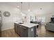 Bright kitchen features an island with sink, stainless steel appliances and opens to the living and dining area at 1627 Mclucas Ln, The Villages, FL 34762