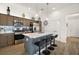 Open kitchen features an island with bar stool seating, and stainless steel appliances and wood-look flooring at 1627 Mclucas Ln, The Villages, FL 34762