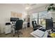 Bright home office featuring two workstations, ceiling fan, and large window overlooking the neighborhood at 1627 Mclucas Ln, The Villages, FL 34762