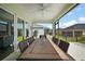 Screened lanai showing dining table with seating, ceiling fan, and sliding glass doors to the home interior at 1627 Mclucas Ln, The Villages, FL 34762