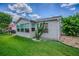 View of home's sunny backyard and patio with lush green lawn at 17009 Se 96Th Chapelwood Cir, The Villages, FL 32162