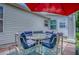 Cozy backyard patio with outdoor dining set and red umbrella at 17009 Se 96Th Chapelwood Cir, The Villages, FL 32162