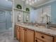 Bathroom vanity with granite counters, wooden cabinets, and decorative wreaths and flowers at 1701 Lakewood Dr, The Villages, FL 32162