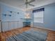 Cozy bedroom with blue walls, wood floors, built-in desk, and large window with natural light at 1701 Lakewood Dr, The Villages, FL 32162