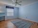 Comfortable bedroom with blue walls, hardwood floors, ceiling fan, and natural light from the window at 1701 Lakewood Dr, The Villages, FL 32162