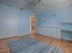 Bright bedroom featuring blue walls, built-in shelving, hardwood floors, and ample closet space at 1701 Lakewood Dr, The Villages, FL 32162