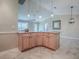 Kitchen island featuring wooden cabinets and granite countertops, seamlessly connecting to a well-lit living area at 1701 Lakewood Dr, The Villages, FL 32162