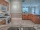 Spacious kitchen with wooden cabinets, stainless steel sink, granite counters, and seamless flow to the living area at 1701 Lakewood Dr, The Villages, FL 32162