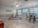 Open-concept living room with dining area, tile floors, ceiling fan, and plantation shutters for a bright and airy feel at 1701 Lakewood Dr, The Villages, FL 32162