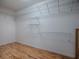 Spacious walk-in closet with wood floors and ample shelving for optimal storage at 1701 Lakewood Dr, The Villages, FL 32162