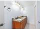 Bathroom features granite vanity, double sinks, framed mirror, overhead lighting, and white tiles at 17068 Se 96Th Chapelwood Cir, The Villages, FL 32162
