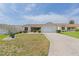 Inviting single-story home featuring a manicured front yard, attached garage, and a clean, well-maintained facade at 17068 Se 96Th Chapelwood Cir, The Villages, FL 32162