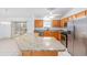 Bright kitchen with granite countertops, stainless steel appliances, and a breakfast bar island at 17068 Se 96Th Chapelwood Cir, The Villages, FL 32162