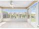 Bright sunroom with tile flooring, ceiling fan, and multiple windows offering ample natural light and views of the backyard at 17068 Se 96Th Chapelwood Cir, The Villages, FL 32162