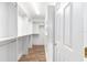 A walk-in closet features custom shelving and a clothing rack with vinyl wood flooring at 17068 Se 96Th Chapelwood Cir, The Villages, FL 32162