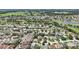 Expansive aerial view of a vibrant residential community with lush landscaping, golf course, and tranquil lake at 17108 Se 76Th Creekside Cir, The Villages, FL 32162