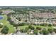 A vast aerial perspective highlighting a community with lush greenery and a nearby lake at 17108 Se 76Th Creekside Cir, The Villages, FL 32162