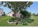 Spacious backyard featuring a garden bed with colorful flowers and lush green grass at 17108 Se 76Th Creekside Cir, The Villages, FL 32162