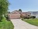 Attractive home with a well-kept lawn, flowering plants, and an American flag, offering curb appeal at 17108 Se 76Th Creekside Cir, The Villages, FL 32162