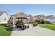 Pink house with a well-manicured lawn and a golf cart parked on the driveway at 17108 Se 76Th Creekside Cir, The Villages, FL 32162