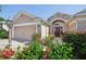 Inviting home entrance with a red front door, lush landscaping, and well-lit pathway at 17108 Se 76Th Creekside Cir, The Villages, FL 32162