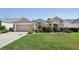 Charming single-story home with beautiful landscaping, American flag, and a driveway at 17108 Se 76Th Creekside Cir, The Villages, FL 32162