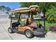 Tan Yamaha golf cart with comfortable striped seats and overhead canopy at 17108 Se 76Th Creekside Cir, The Villages, FL 32162