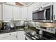 Modern kitchen detail showcasing stainless steel appliances, granite countertops, and stylish backsplash at 17108 Se 76Th Creekside Cir, The Villages, FL 32162