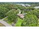 Stunning lakefront home with a pool, lush greenery, and a winding driveway at 1930 Country Club Rd, Eustis, FL 32726