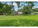 Lush backyard featuring mature trees and a screened pool enclosure at 1930 Country Club Rd, Eustis, FL 32726