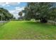 Expansive green backyard with mature trees and fenced perimeter at 1930 Country Club Rd, Eustis, FL 32726
