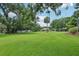 Spacious backyard with lush lawn, mature trees, and convenient playset at 1930 Country Club Rd, Eustis, FL 32726