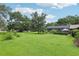 Expansive backyard featuring lush lawn and a screened pool enclosure at 1930 Country Club Rd, Eustis, FL 32726