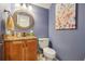 Cozy half bathroom features a granite countertop, a wooden cabinet, and floral wall decor at 1930 Country Club Rd, Eustis, FL 32726