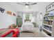 Bright bedroom features a ceiling fan, a window for natural light, and a white bookshelf at 1930 Country Club Rd, Eustis, FL 32726