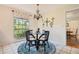 Cozy dining area with a round table, chandelier, and a window view of the lush outdoors at 1930 Country Club Rd, Eustis, FL 32726