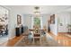 Bright dining room featuring a farmhouse style table, wood floors, and ample natural light from a large window at 1930 Country Club Rd, Eustis, FL 32726