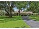 Charming single-story home with mature trees, lush lawn, and a circular driveway providing ample parking space at 1930 Country Club Rd, Eustis, FL 32726