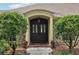 Inviting front entrance with a dark wood door, decorative sidelights, and manicured shrubs for added privacy at 1930 Country Club Rd, Eustis, FL 32726