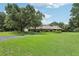 Spacious lawn featuring a well-manicured landscape with mature trees leading to a single-story home at 1930 Country Club Rd, Eustis, FL 32726