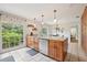 Bright kitchen with stainless steel appliances, wooden cabinets, and a view of the landscaped yard at 1930 Country Club Rd, Eustis, FL 32726