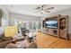 Bright living room with hardwood floors, entertainment center, and french doors to the backyard at 1930 Country Club Rd, Eustis, FL 32726