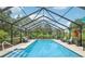 Stunning in-ground pool with screened enclosure, surrounded by lush landscaping and comfortable seating at 1930 Country Club Rd, Eustis, FL 32726