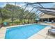 Inviting screened-in pool area surrounded by lush greenery and comfortable seating at 1930 Country Club Rd, Eustis, FL 32726